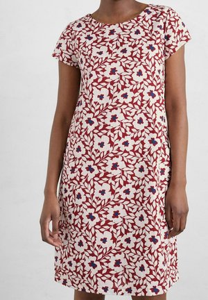 Vestido floral en rojo, crema y azul; mangas cortas, cuello redondo; presenta un patrón de flores blancas con centros azules y hojas verdes.