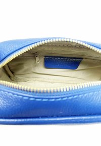 Pochette in pelle blu texture con zipper dorato, dotata di un interno beige e una piccola tasca con zip. Etichetta visibile all'interno.