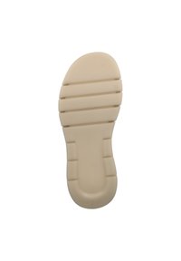 La suela de zapato de goma beige presenta una superficie texturizada con ranuras horizontales y bordes redondeados, que ofrecen agarre y flexibilidad.