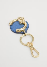 Blå lærnøkkelring med en gullmetalldel, sirkulær form, teksturert overflate og glatte hardware-detaljer.