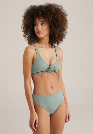 Ribotuotas mezgimo bikini rinkinys pudros žalios spalvos. Viršus turi rišamus priekinius kraštus ir plačias petnešas; apačia pasižymi aukštu liemeniu ir vidutiniu dengimu.
