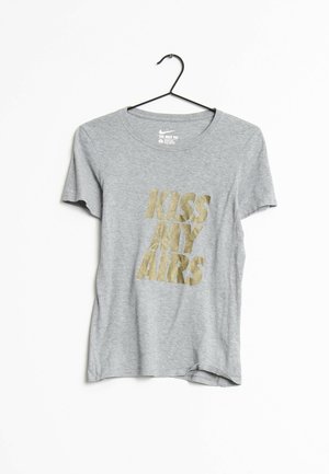Camiseta gris de manga corta de Nike en percha negra con texto dorado "KISS MY AIRS" centrado en el frente sobre fondo blanco.