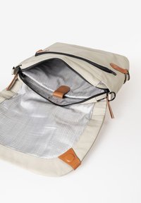 Zaino beige con apertura con zip, dettagli in pelle e rivestimento interno a quadri. Presenta un fondo piatto e angoli arrotondati.