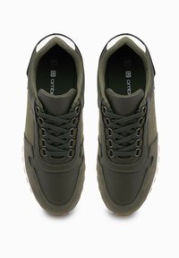 Zielone trampki wykonane z połączenia gładkiej skóry i teksturowanej tkaniny. Wiązane sznurowadłami, z gumową podeszwą i wyściełanym kołnierzem.