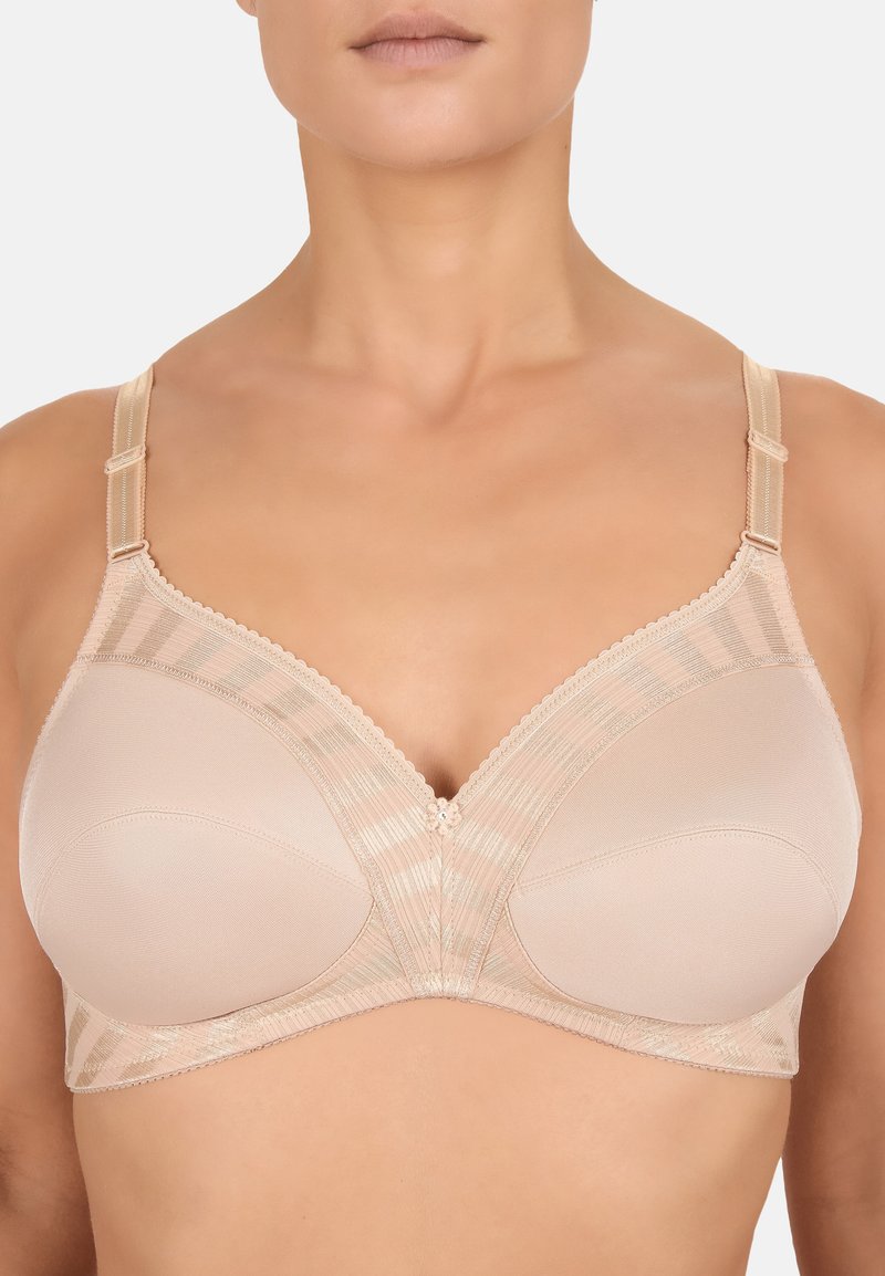 Reggiseno beige con coppe sagomate, sovrapposizione in rete a righe orizzontali, bordi ondulati e decorazione centrale. Spalline regolabili.