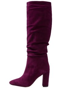 Bota de ante fucsia hasta la rodilla con un diseño arrugado, punta afilada y un tacón alto grueso. Textura suave sin detalles de hardware visibles.
