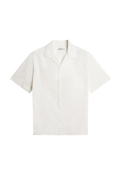 Biała, krótkorękawowa koszula zapinana na guziki z luźnym kołnierzem i kieszenią na piersi, rozłożona na płasko na białym tle.