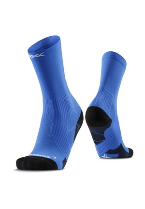 Een paar blauwe sportsokken met zwarte hiel- en teenstukken, geribbelde structuur en wit logo nabij de bovenkant en op de teen.