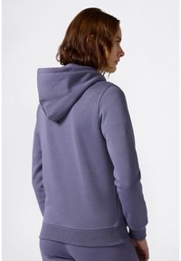 Sudadera morada hecha de material de forro polar, con una capucha grande, puños acanalados y dobladillo. Tejido liso y texturizado sin patrones.