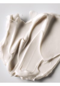 Thick, creamy white moisturizer spread with smooth, glossy texture featuring gentle waves and peaks, against a plain white background.