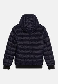 Giacca invernale blu navy con cappuccio, caratterizzata da una texture trapuntata, polsini e orlo a coste e una finitura liscia e lucida.