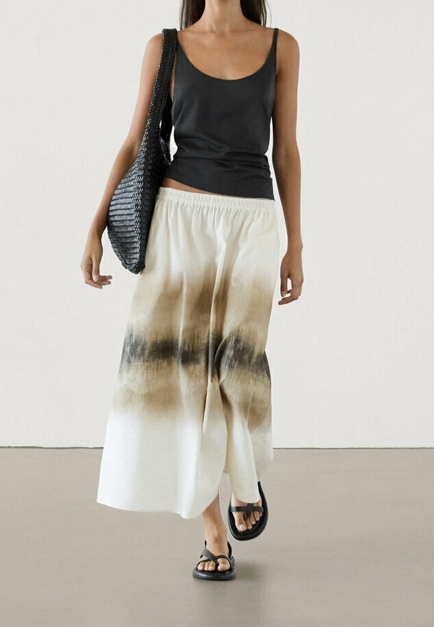 Maxi nederdel i hvid med brunt ombre mønster, vævet stof, elastisk talje, parret med en sort tanktop og sorte sandaler.