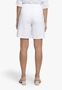 Witte linnen short met een relaxte pasvorm, voorzien van zijzakken, een soepele textuur en achterzakken met een flap. Eenvoudig ontwerp met een nette afwerking.