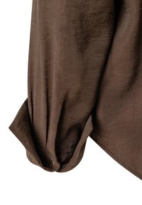Braune Bluse mit einer weichen, glatten Textur, einem geknöpften Manschetten und einem lockeren Schnitt. Sie zeigt einen subtilen Glanz und klare Linien.