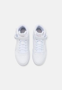 Białe skórzane sneakersy za kostkę z sznurowaniem, wyściełanym kołnierzem, perforowanym czubkiem i małym logo na pasku w okolicy kostki.