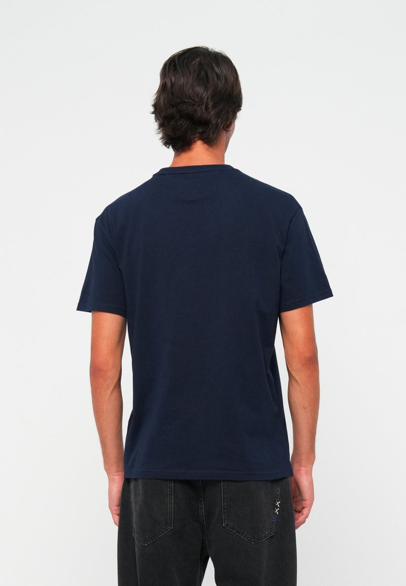 T-shirt en coton bleu marine à manches courtes et col rond. Présente un design simple, sans logos ni motifs visibles. Coupe standard.