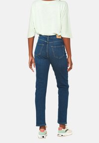 Mörkblå denimjeans med hög midja, fem fickor och slim fit. Detaljerad sömnad och en läderetikett vid den bakre midjan.