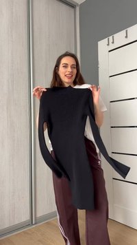 Juoda nertinė suknelė su ilgomis rankovėmis, prigludęs siluetas ir aukšta apykaklė, pateikta neutraliame fone.