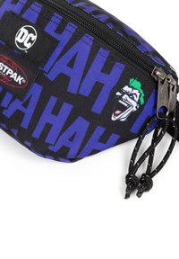 Sacca zip nera e viola con motivo testuale "HAH", grafica Joker e due cordini neri per la chiusura. Materiale in tessuto resistente.