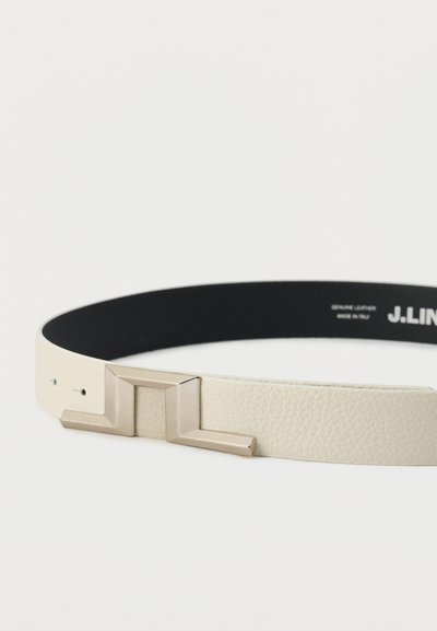 Ζώνη από ανάγλυφο δέρμα σε κρεμ χρώμα με γωνιώδη, ασημί μεταλλική αγκράφα και μαύρη εσωτερική επένδυση, απλωμένη επίπεδη σε λευκό φόντο.