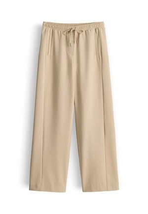 Lichtbeige wijde broek met een elastische tailleband en een trekkoord. Heeft twee voorzakken en een gladde textuur.