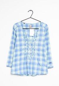 Camicia a maniche lunghe a quadri in azzurro chiaro e verde, con scollo a V, fronte arricciato e dettagli con bottoni. Il materiale sembra leggero.