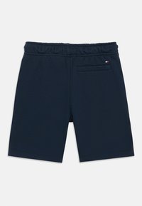 Tumši zili šorti, izgatavoti no mīksta auduma, ar elastīgu jostasvietu un vienu aizmugures kabatu ar izšūtā logotipa detaļu.