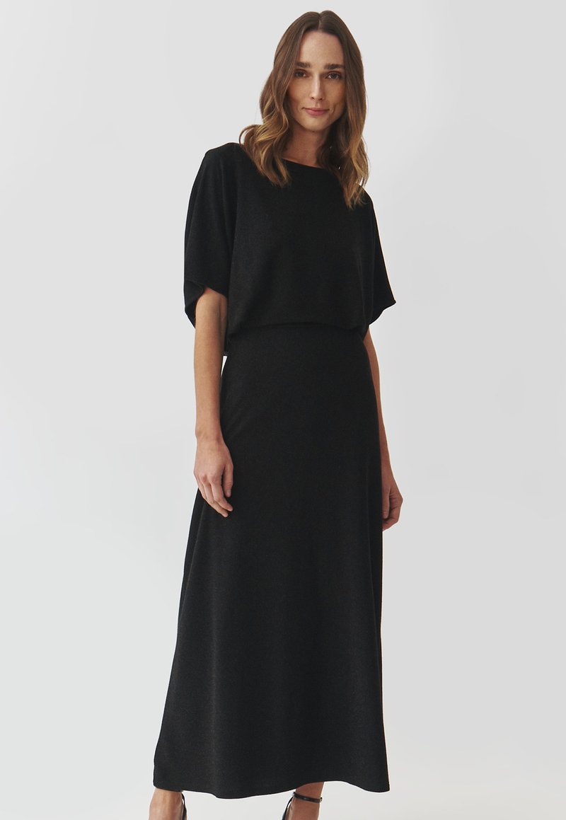 Schwarzes Maxikleid mit kurzen, weiten Ärmeln; glatter Stoff mit einem subtilen Glanz; taillierter Oberteil, fließender Rock und schlichte Silhouette.
