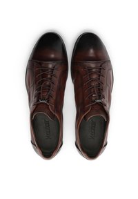 Rjavi usnjeni čevlji z gladkim zaključkom, zaobljenim prstom in zapletenim šivom. Imajo zavezovanje z vezalkami in notranji logotip.