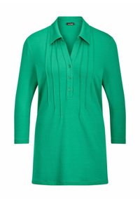 Chemise verte à manches longues avec col, patte de boutonnage à trois boutons et plis cousus verticaux sur le devant.