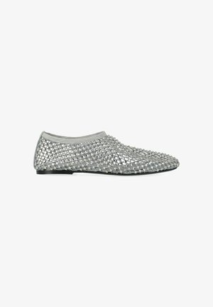 Scarpa slip-on piatta argento con design in rete trasparente decorata con brillanti strass e suola sottile nera.