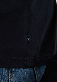 Navyblauwe katoenen t-shirt met een ronde halslijn, korte mouwen en een zijnaadlabel. De stof heeft een gladde textuur en zichtbare stiksels.