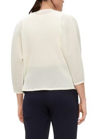 Crème, geribde gebreide pullover met 3/4 mouwen, ronde hals en een relaxte pasvorm. De achterkant heeft een lichte drop en afgewerkte randen.