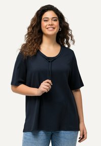 Maglietta in cotone blu navy con maniche corte, scollatura rotonda e dettaglio con coulisse frontale. Vestibilità casual, texture liscia.