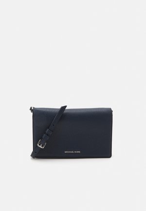 Czarna torebka na ramię z tłoczonej skóry z regulowanym paskiem i srebrną klamrą, z małym złotym logo "Michael Kors" na środku z przodu.