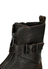 Černá kožená kotníková bota s textured povrchem, s dekorativní sponou, bočním zipem a akcenty zvířecího vzoru na zadní straně.