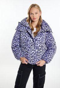 Geacă puffer cu imprimeu leopard purple, cu un guler mare, fermoar în față și două buzunare laterale. Asortată cu pantaloni cargo negri.