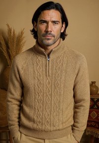Pull à zip beige en tricot avec un col montant, présentant un motif en torsades texturé et des poignets côtelés, fabriqué à partir d'un tissu doux et texturé.