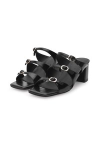 Black block-heel sandals featuring wide straps and flat buckles, made from glossy leather with a square toe design and smooth texture.