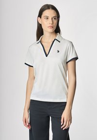 Polo bianco con scollo a V, dettagli blu navy sul colletto e sulle maniche, con un piccolo logo ricamato a sinistra.