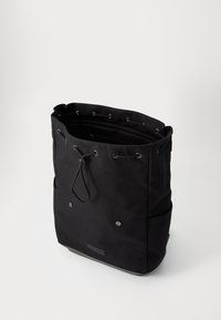 Black tote bag made of durable fabric, featuring drawstring closure, two side pockets, and smooth texture with subtle branding.