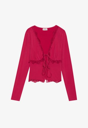 Piros, hosszú ujjú felső mély V-nyakkivágással, csipkés szegéllyel a széleken és elöl megkötő záródással. Sima tapintású, testhezálló fazon.