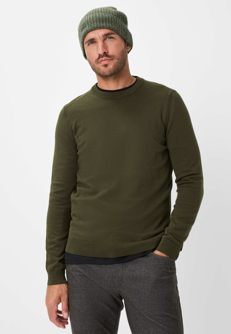 Maglione verde oliva a maniche lunghe con collo rotondo, polsini a coste e finitura testurizzata, abbinato a pantaloni grigi con texture e un berretto coordinato.
