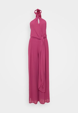 Roosa, lühikeste varrukateta kombekas, mis on valmistatud siledast kangast, funktsioneerib kaela- ja võtmeaugu lõikega ning sidumisvööga, mis võimaldab reguleeritavat sobivust.