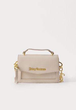 Sac à main beige Juicy Couture avec poignée supérieure, logo en lettres dorées sur le rabat avant, et détails métalliques dorés sur les côtés.
