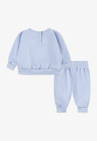 Light blue sweat suit featuring a pullover top with ribbed cuffs and hem, and matching pants with an elastic waistband and tapered legs.