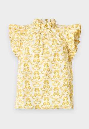 Blouse blanche sans manches avec épaules à volants et col montant froncé, présentant un motif floral et feuillage jaune.
