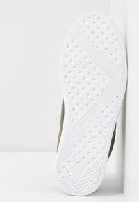 Zielone płócienne buty z teksturowaną białą gumow�ą podeszwą, z ukośnym wzorem oraz okrągłym logiem wytłoczonym. Rozmiar 37 widoczny na podeszwie.