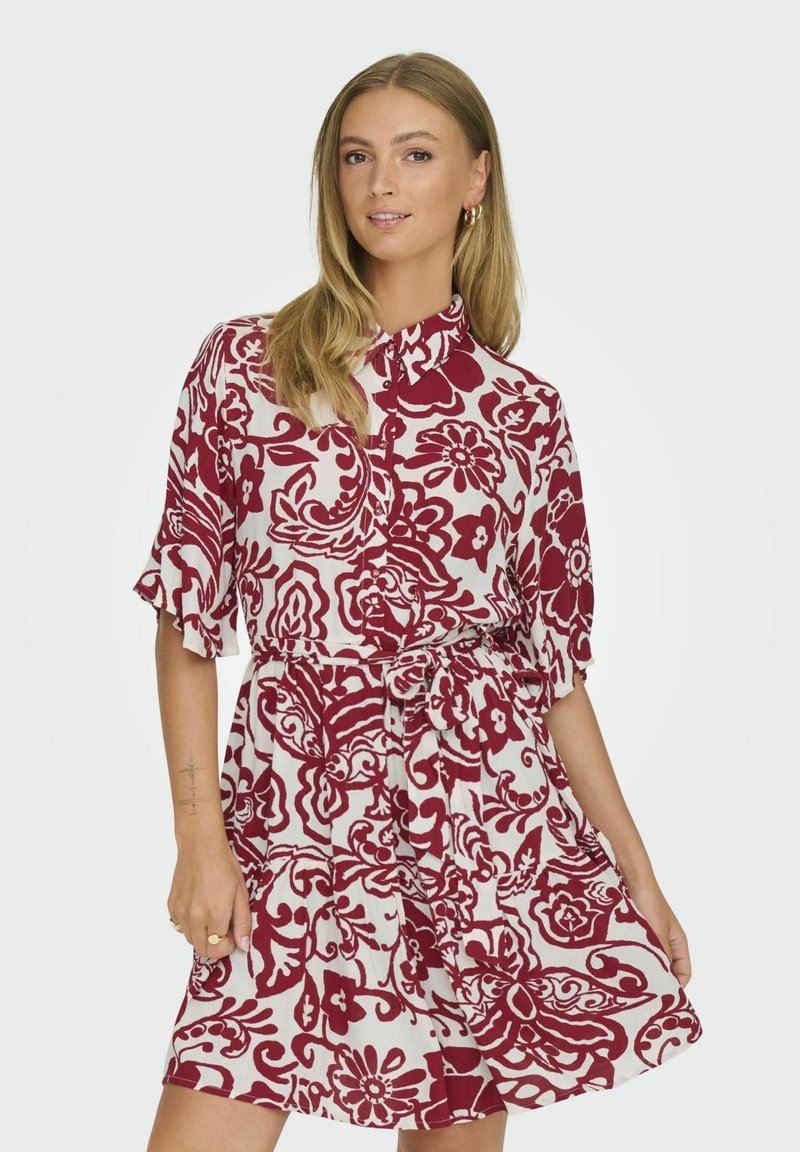 Blumengemustertes Kleid in Weiß und Dunkelrot, mit kurzen rüschengestützten Ärmeln, Knopfleiste und einer taillierten Taille mit einem passenden Gürtel.