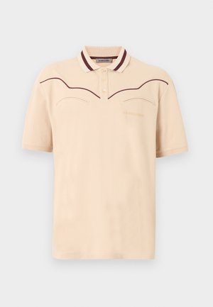 Beige poloshirt med korte ærmer, mørkebrune pipingdetaljer over brystet og på kraven, tre knapper foran og et diskret broderet logo.